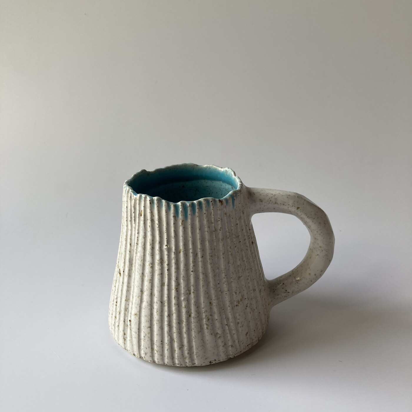 A barnacle mug with combed surface and plain pulled handle