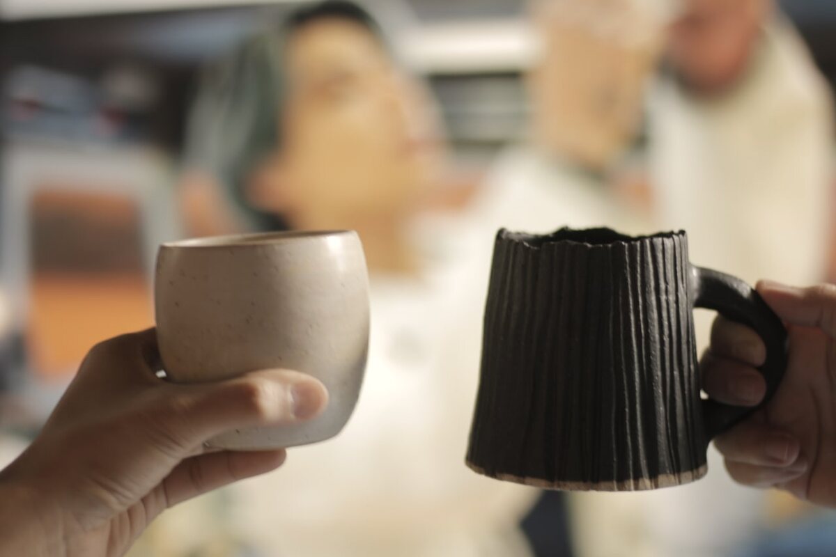 Held between two people, mid conversation. Handmade Philippine stoneware by AWIS in everyday use.