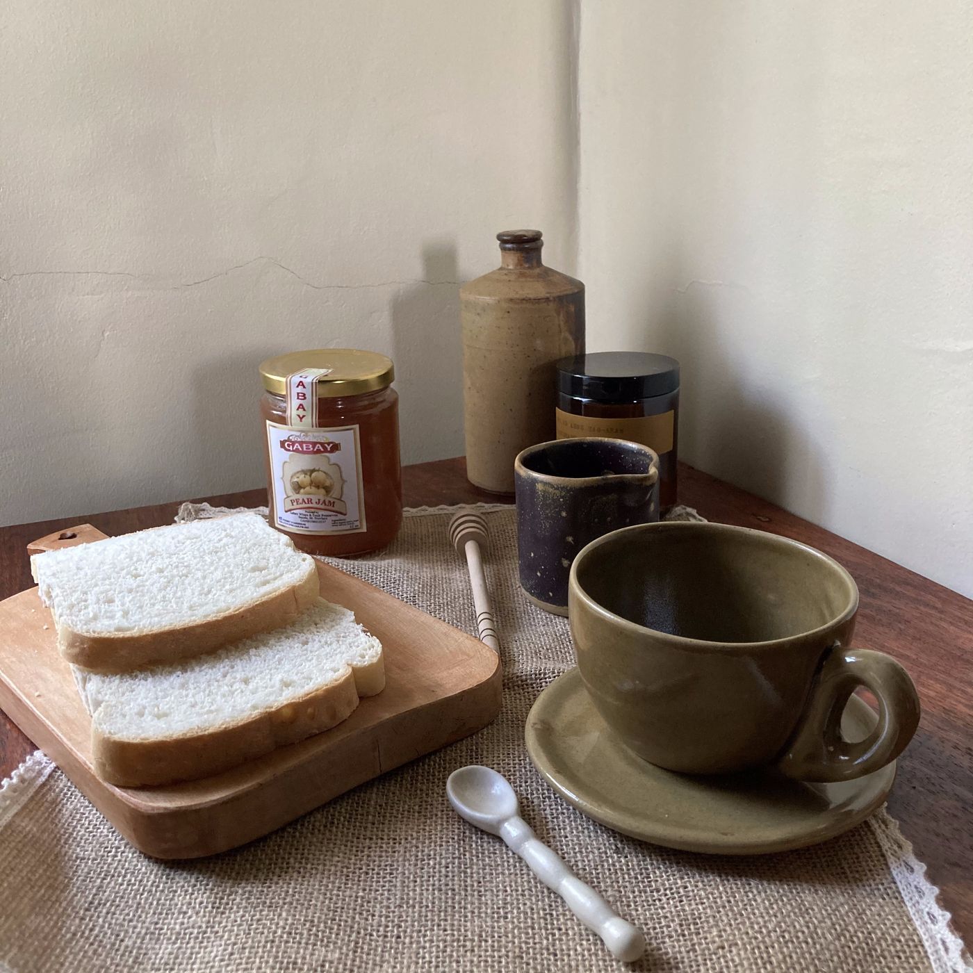 Handmade stoneware cappuccino cup and creamer on a dark surface, Philippine pottery by AWIS