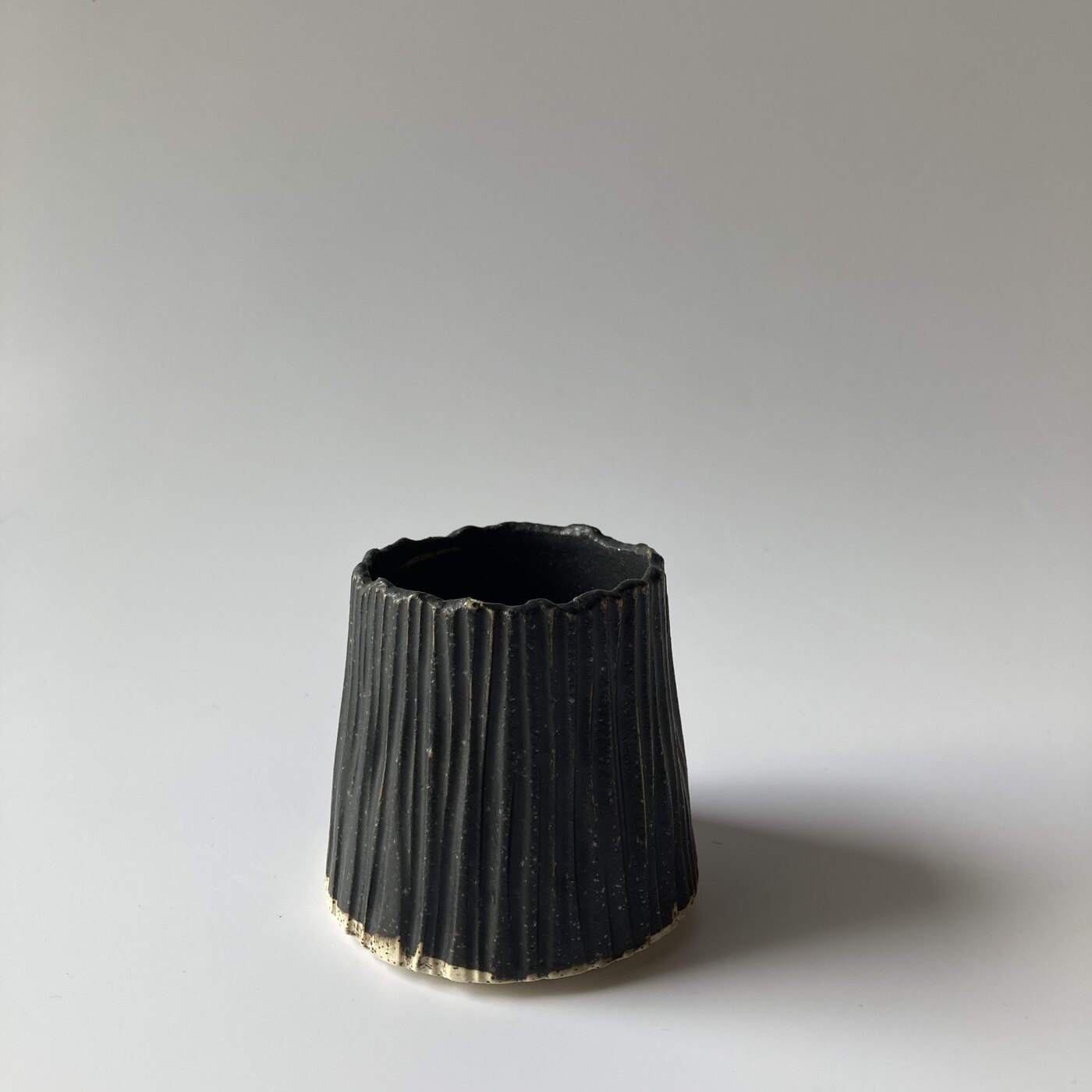 A small combed barnacle cup in charcoal glaze